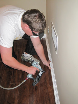 Man using air nailer to install molding