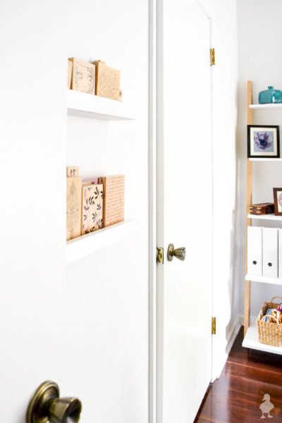 white doors inside office with picture ledges and bookshelf