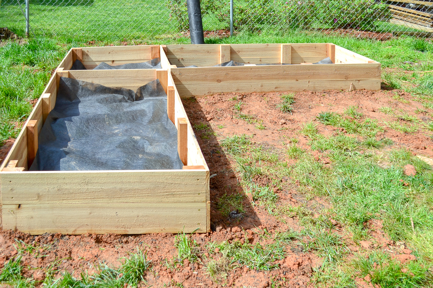 finished cedar raised garden beds - laying down landscaping fabric weedblocker