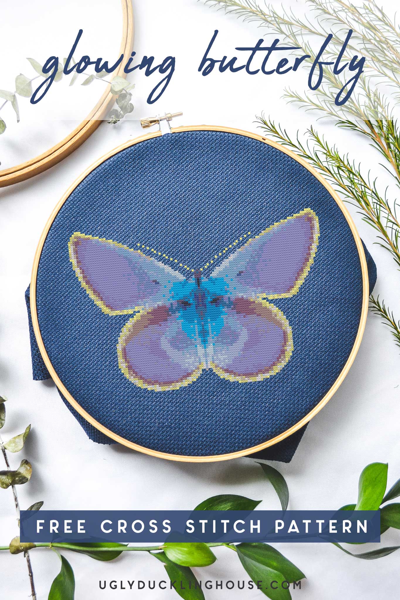 glowing butterfly cross stitch on navy embroidery hoop