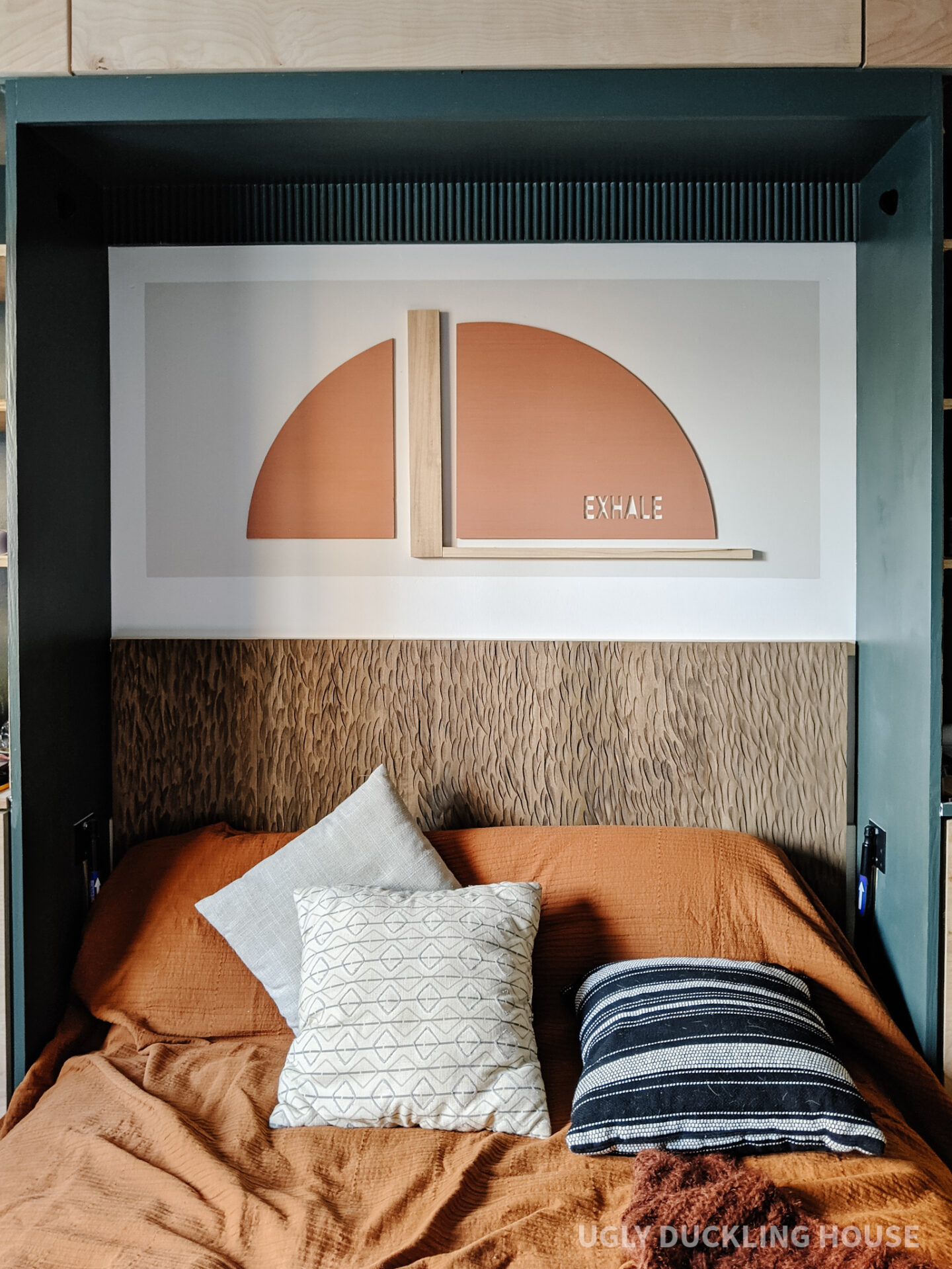 murphy bed nook reveal - exhale rust arch color block art and carved wood headboard with neutral bedding and rust coverlet